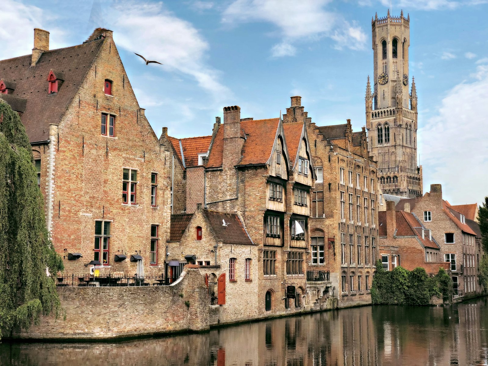 Historic brick buildings along a Bruges canal in daylight