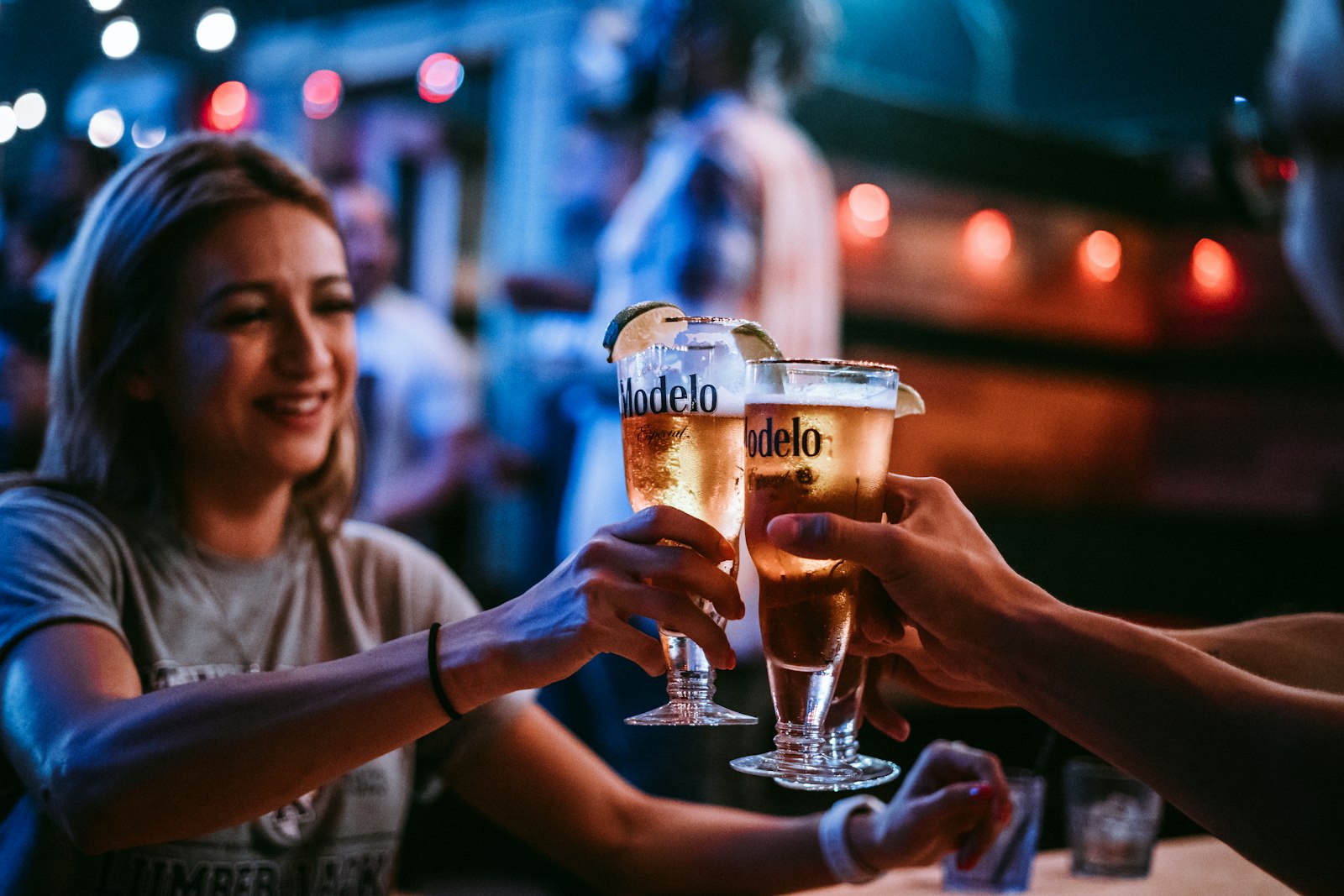 Three friends toasting their glasses at a bar