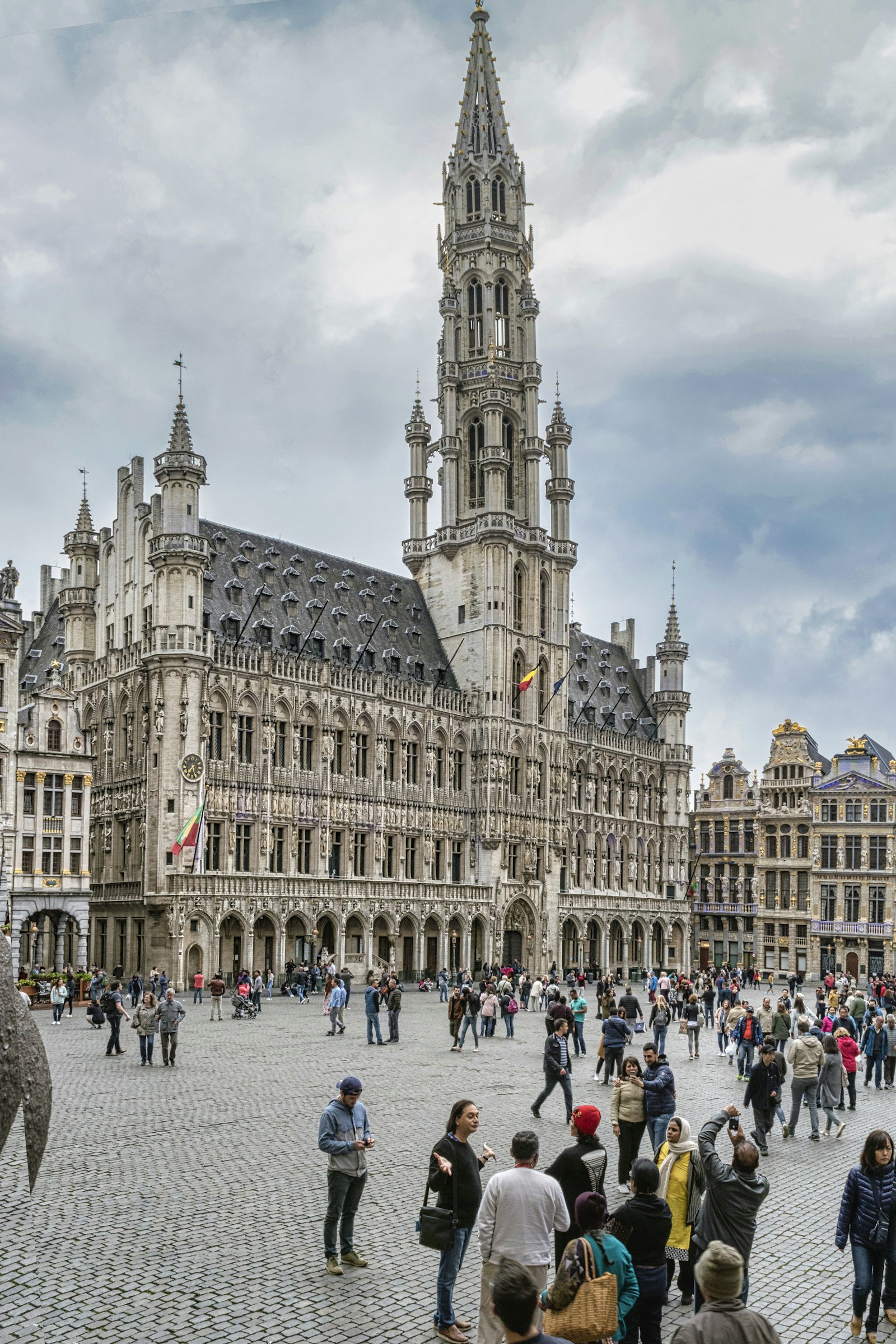 People walking past a white historic building in Brussels